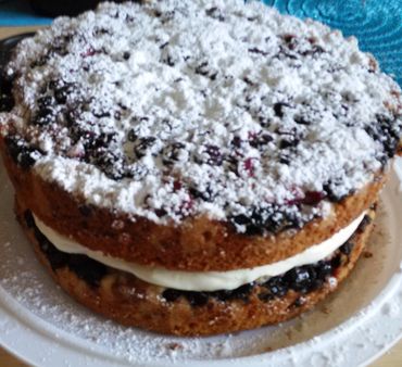 Berry cake with cream filling and powdered sugar on top.