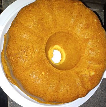 Golden brown bundt cake on a white plate.