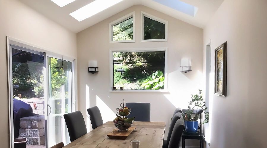 after image of a dining room with new windows, sliding door and skylight windows