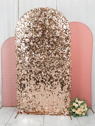 Three pink backdrop panels including a sequined one with flowers on the floor.