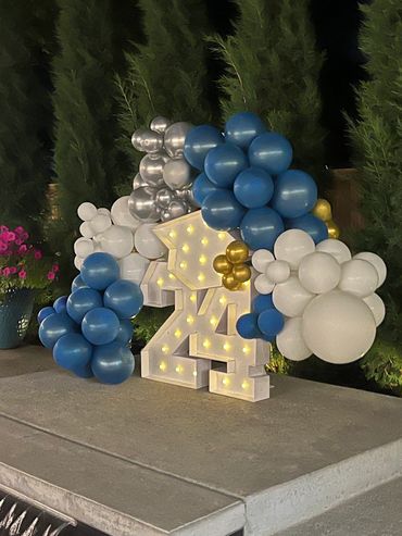 Light up marquee numbers with balloon garland for a graduation party.