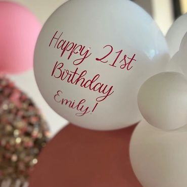 White balloon with "Happy 21st Birthday Emily!" in red text.