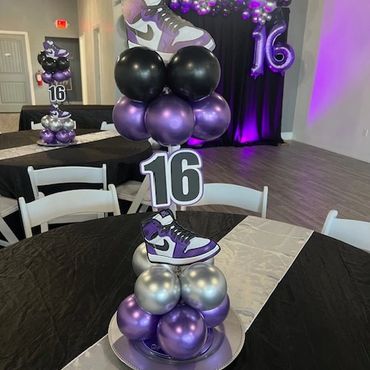 Nike Sneaker centerpieces in purple, black, and silver with balloons.