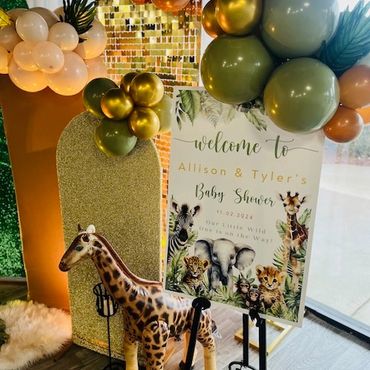 Animal-themed baby shower decor with balloons and a giraffe figure.