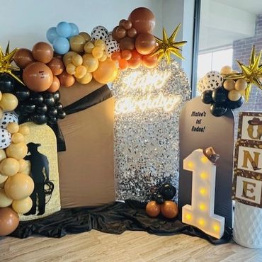 1st Birthday party in the "Rodeo" theme, showing backdrop area with arches and balloons.
