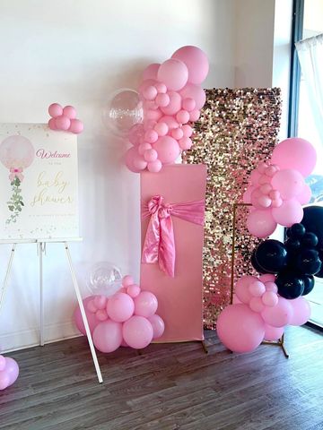 Pink and black balloon decorations with a baby shower welcome sign.