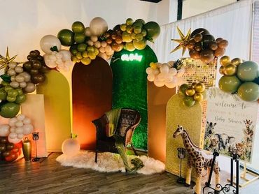 Safari themed backdrop for a "Wild One is on the Way!" baby shower.