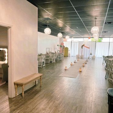 Bright event space with elegant chandeliers and wedding setup.