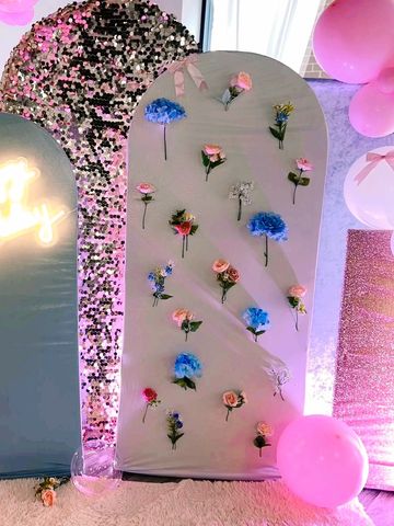 Colorful birthday decoration with balloons, flowers, and a glowing Happy Birthday sign.