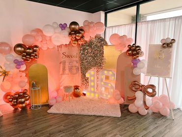 Sweet 16 birthday party setup with balloons and illuminated numbers.