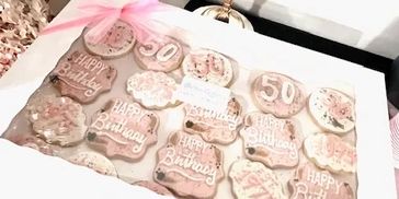 Decorated cookies celebrating a 50th birthday with pink and white icing.