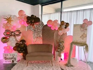 A cozy teddy bear-themed photo setup with balloons and a small couch.