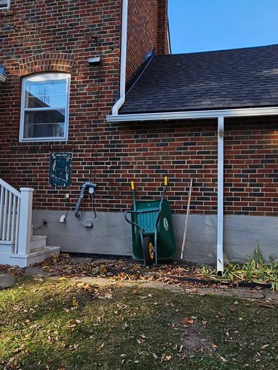 Downspout and extension directing roof runoff away from a home foundation