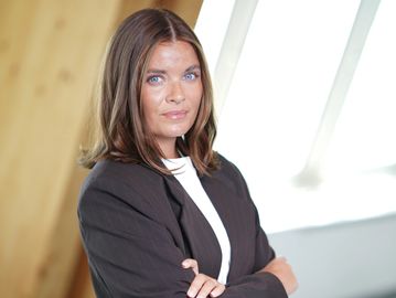 Confident woman in professional attire with folded arms.