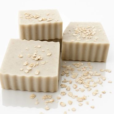square beige bars of soap with scalloped edges, topped with oats