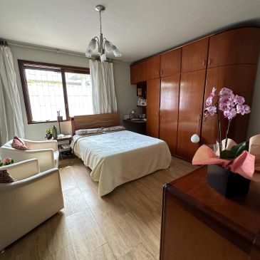 Quarto arrumado com cama king-size e armários de madeira.
