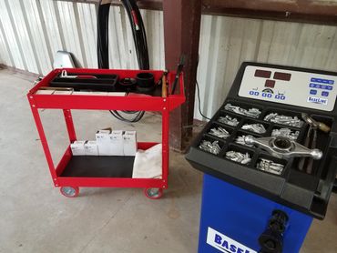 Red tool cart with boxes and a blue machine with metal parts compartments.