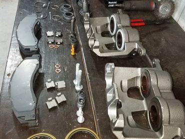 Disassembled automotive brake components laid out on a workshop table.