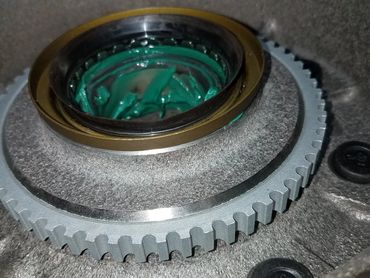 Close-up of a mechanical gear assembly with green grease lubrication.