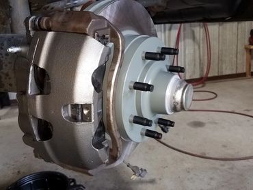 Close-up of a vehicle's brake assembly with a new rotor and caliper.