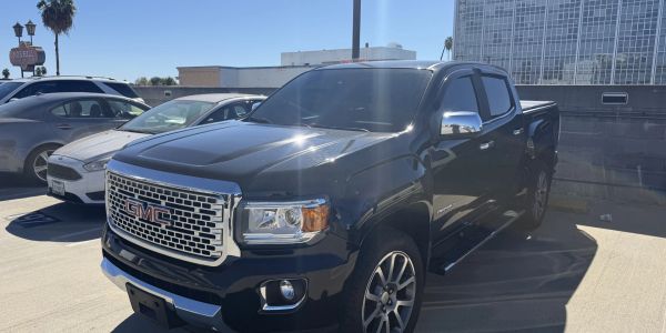 Black GMC pickup truck parked in daylight.