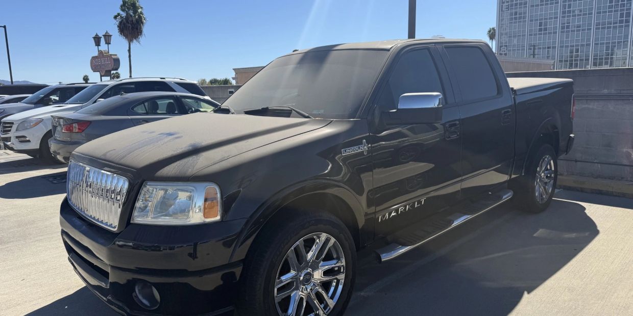 Black Lincoln Mark LT pickup truck parked in the sun.