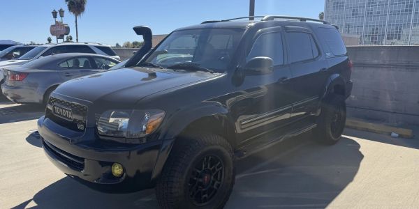Black Toyota SUV parked in a sunny parking lot.