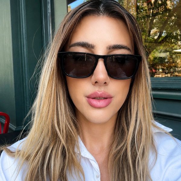Woman wearing black sunglasses and light makeup.