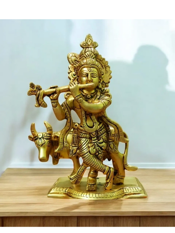 Brass statue of Lord Krishna playing flute with a cow.