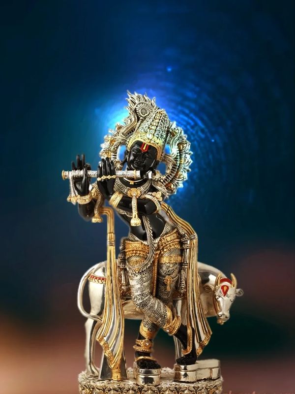 Intricate statue of Lord Krishna playing the flute with a cow in the background.