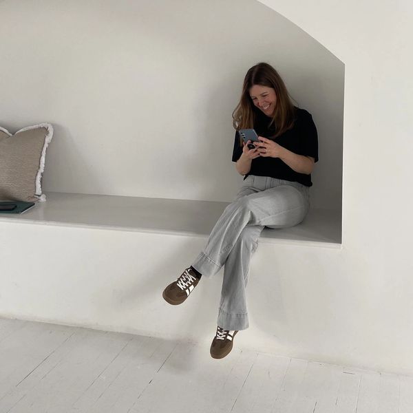 A picture of Hollie sitting and smiling while looking down on at her phone.