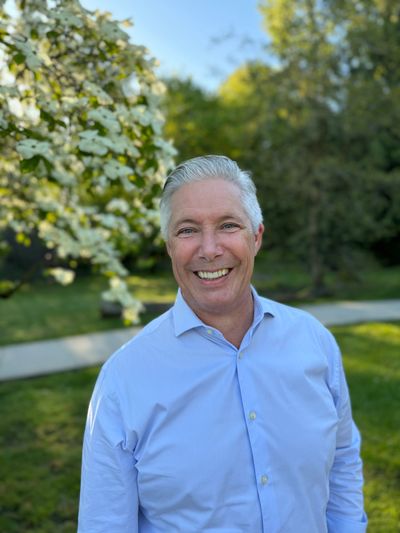 Dwayne Mason in a Blue shirt with silver hair and blue eyes.