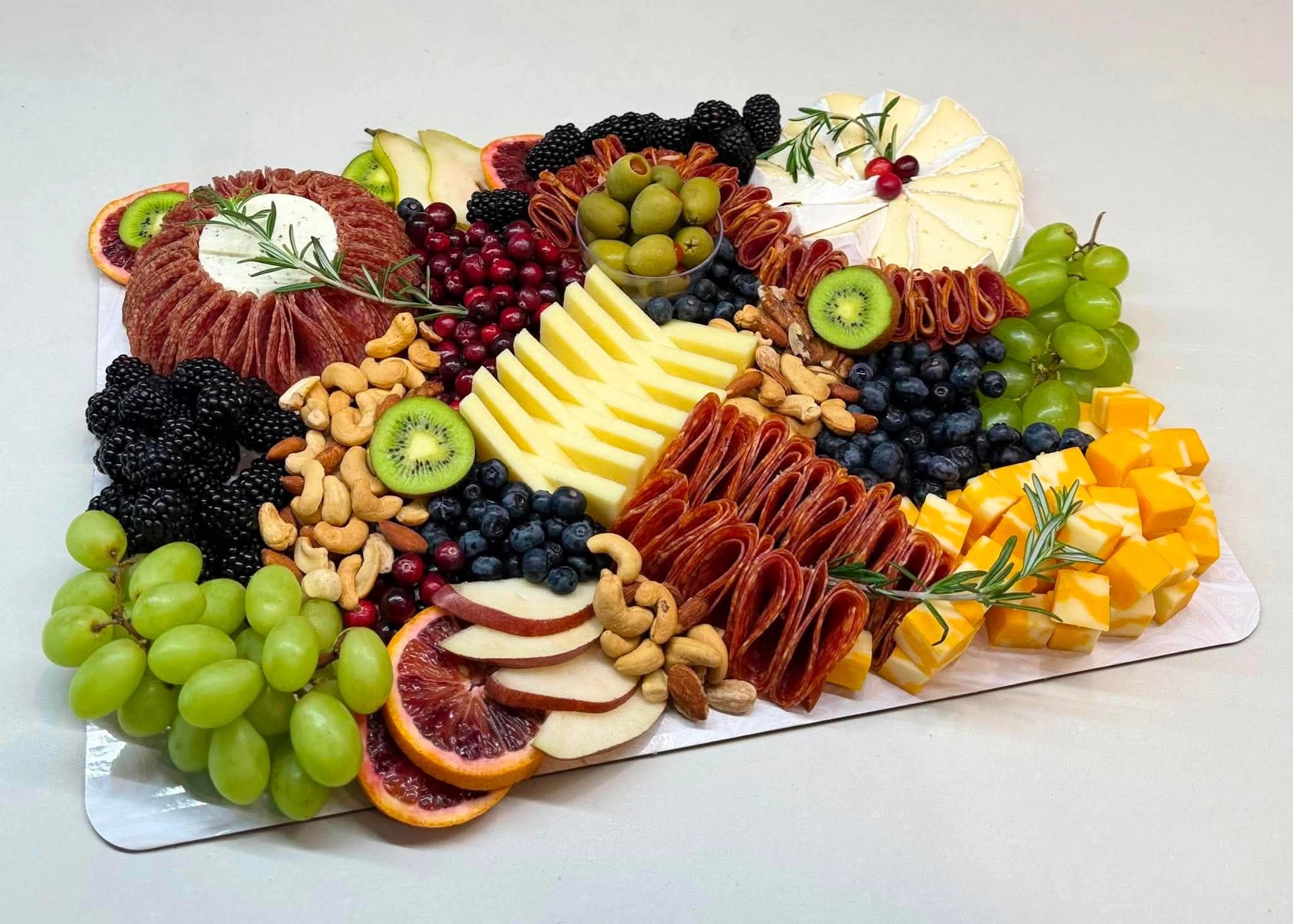 Colorful charcuterie board with fruits, nuts, cheese, and meats.