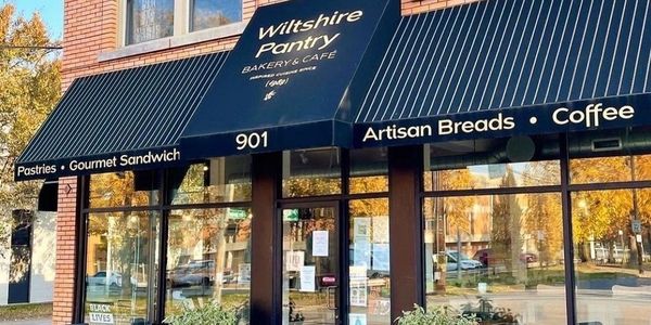 Exterior of Wiltshire Pantry bakery and cafe with black awning.