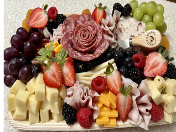 Elegant charcuterie board with fruits, cheeses, and meats arranged beautifully.