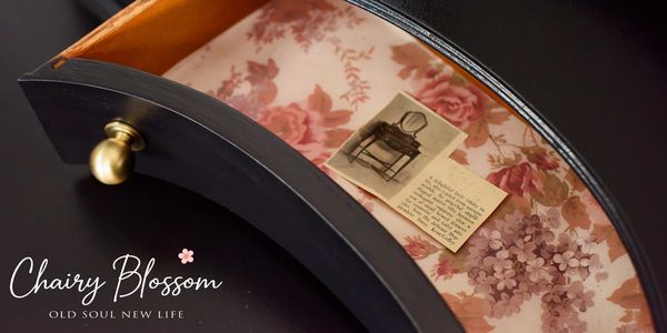Open drawer with floral lining and vintage photo inside.