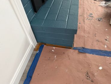 Painted blue brick structure with protective paper on the floor.