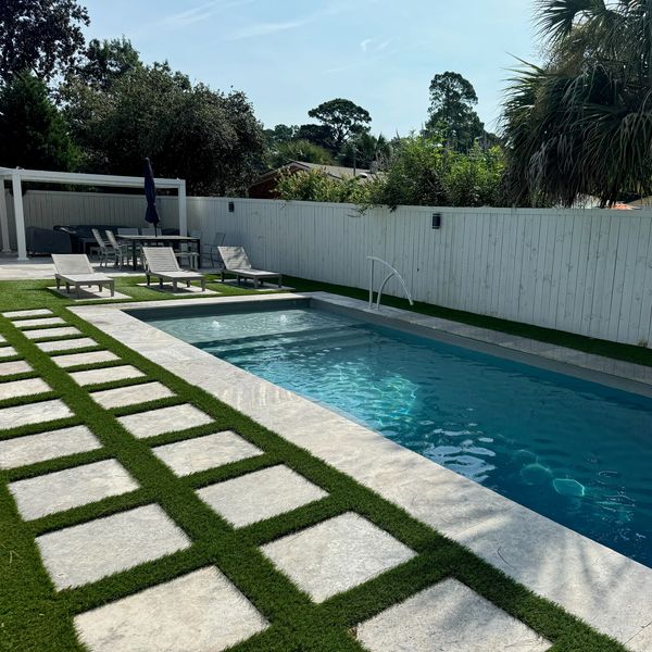 Modern backyard with a pool and sun loungers.