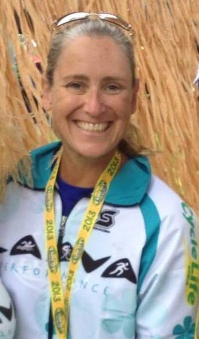 Smiling woman wearing an athlete jacket and medal.