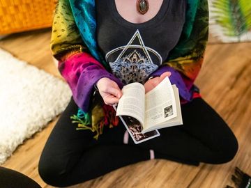 A woman reading about the oracle card she pulled during a cacao ceremony