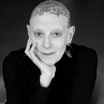 Lavinia smiling, resting her head on her right hand.