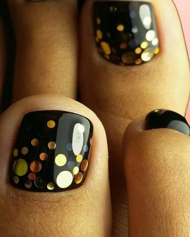 Black toenail polish with gold and silver dots design.