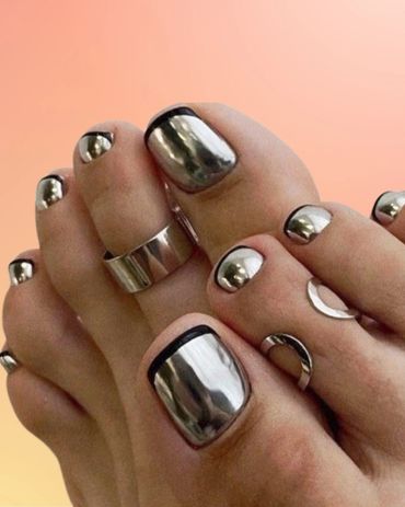 Feet with shiny metallic silver toenail polish and black edges.