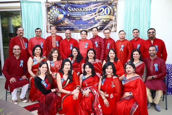 Group photo of people celebrating Sanskriti's 20th anniversary in traditional attire.