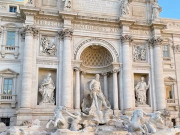 The iconic Trevi Fountain in Rome with detailed sculptures and clear blue sky.