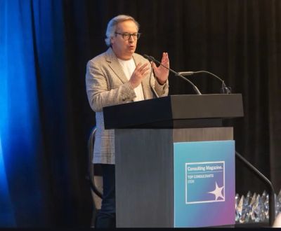 Man speaking at a conference podium.