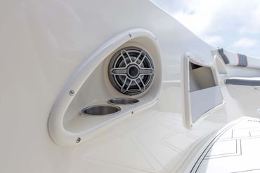 Boat speaker with cup holders integrated into white fiberglass.
