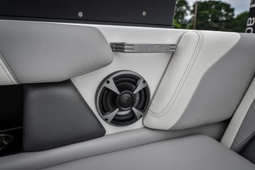 Close-up of a Malibu boat interior speaker and cushioned seating.