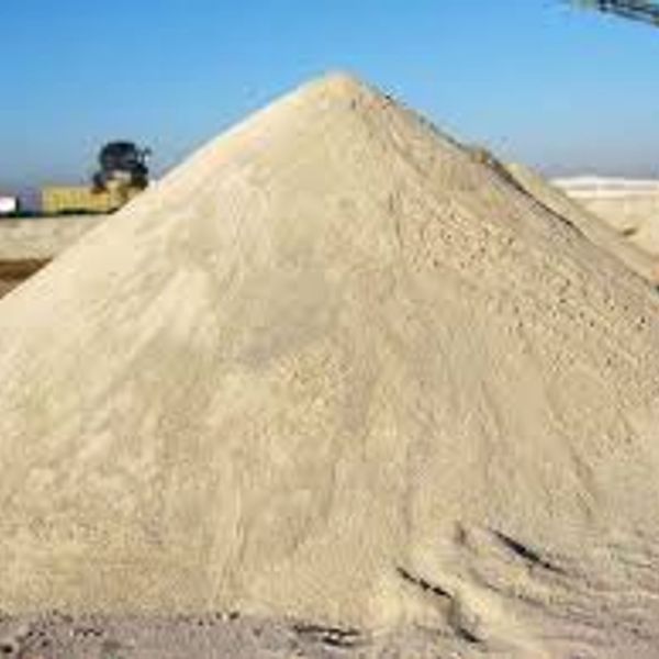 Large pile of sand under clear blue sky.