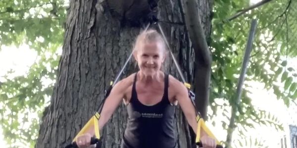 Suzanne Pettit working out with suspension straps hung from tree